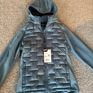 Softshell Everest NY - Softshell jacka från Everest. Inköpt 2023 men aldrig använd. Avtagbar luva. Storlek 158-164. Ljusblå. Nypris 499:-.