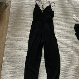 Svart byxdress  - Svart byxdress men öppen rygg. Storlek 8, motsvarar storlek S.