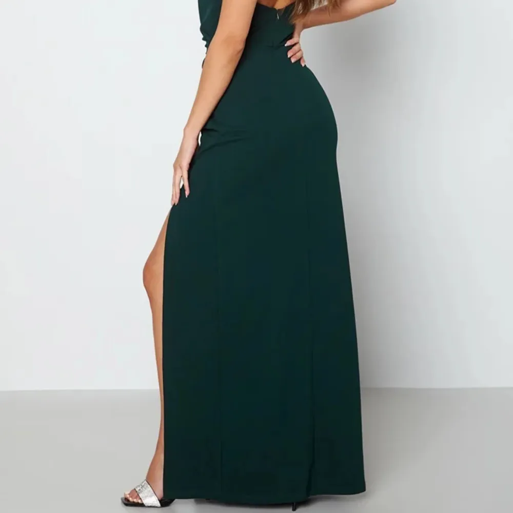 Säljer denna maxiklänning som är perfekt att ha på bal eller liknande. Klänningen har en slits på sidan, är i en fin mörkgrön färg och endast använd en gång. Kom gärna privat för fler bilder🤍Frakt tillkommer. Klänningar.