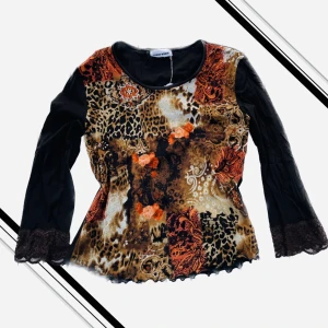 Topp - Cool topp med olika prints i tyget, spets längst ärmen. Passar Xs-M