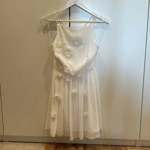 Superfin klänning med blommor - Superfin sommarklänning med blommor, vacker rygg! Aldrig använd och nyskick. Perfekt till skolavslutningen, studenten eller midsommar. Storlek XS-S.