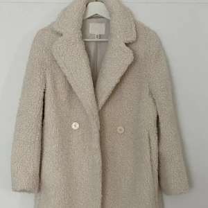 Teddy beige kappa HM - Teddy beige kappa HM. Perfekt skick, använd en gång. storlek xc för höjd upp till 162. Rocken ändrades av en sömmerska och rätade ut sömmen på rygg och ärmar.