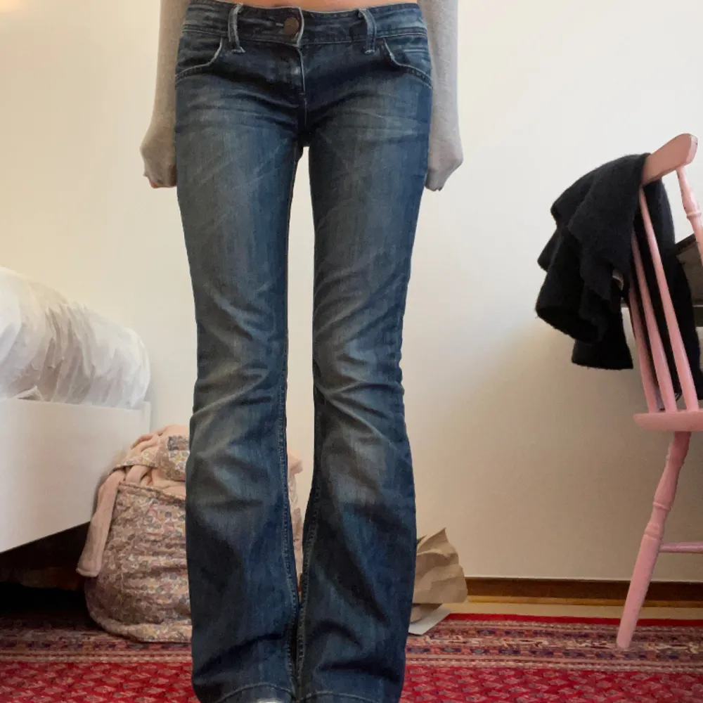 Jättesöta mörkblå lågmidjade jeans köpta secondhand. De är bootcut och har en cool metal-detalj på baksidan och fina bruna detaljer på bakfickorna:) midjemåttet är 40 cm rakt över och innerbenslängden 81 cm. Jag är 170💞. Jeans & Byxor.