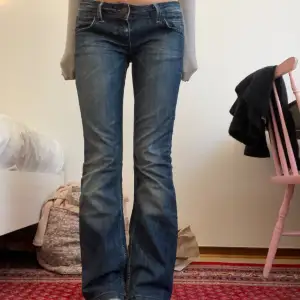 Jättesöta mörkblå lågmidjade jeans köpta secondhand. De är bootcut och har en cool metal-detalj på baksidan och fina bruna detaljer på bakfickorna:) midjemåttet är 40 cm rakt över och innerbenslängden 81 cm. Jag är 170💞