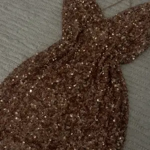 En fest klänning med glitter oaljetter, kort och tajt och passar perfekt till en ute kväll. Öppen i ryggen och har dragkedja. NYPRIS 1200