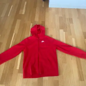 En röd Nike hoodie köpt för 1 år sedan, använd fåtal gånger. Skick 9/10