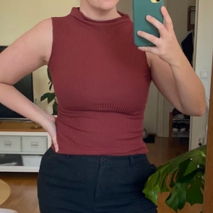 Ribbad topp - Ribbad topp med hög krage från Lindex i storlek XS. Färgen är röd, mer åt det bruna hållet än klarröd. 