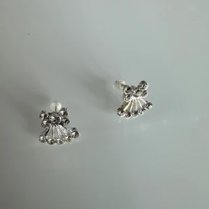 Örhängen  - De små stiftörhängena är förstklassigt och detaljrikt utformade i guld. De imponerar med en slingrande orm i naturtrogen design. Det ger det uttrycksfulla örosmycket elegant glans. Stiftörhängena passar perfekt för en extravagant, originell look.