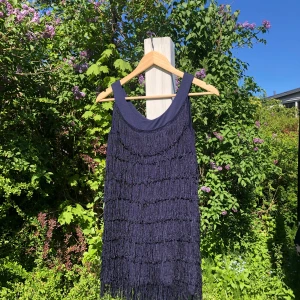 Blå klänning tassles  - Mörkblå kort klänning med tassles på från HM, mjukt och stretchigt material som funkar för xxs-m