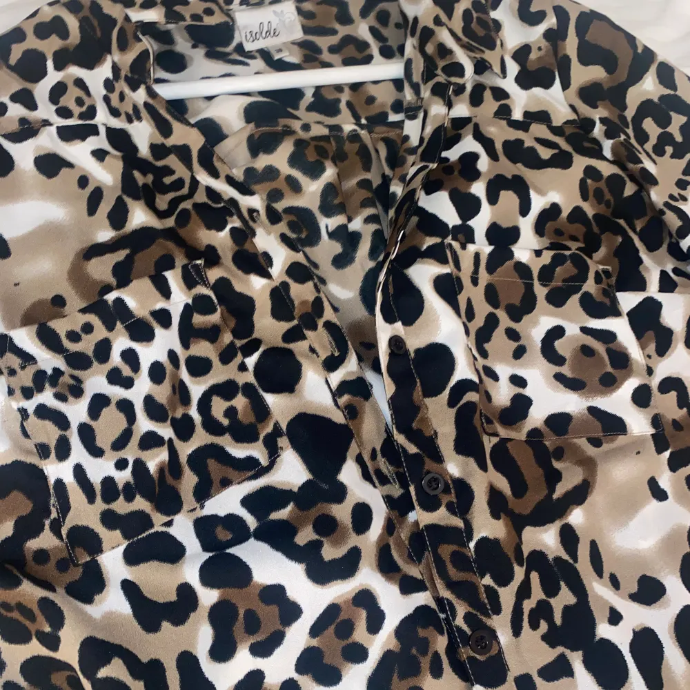 en leopard mönstrad skjorta som man kan knyta upp och är super snygg och iconic att ha på sig.. Skjortor.