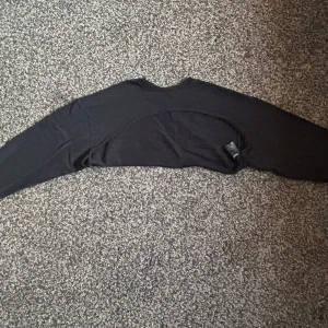 Svart axeltröja  - Typ helt oanvänd, tröjan är lös i armarna och täcker bara axlarna