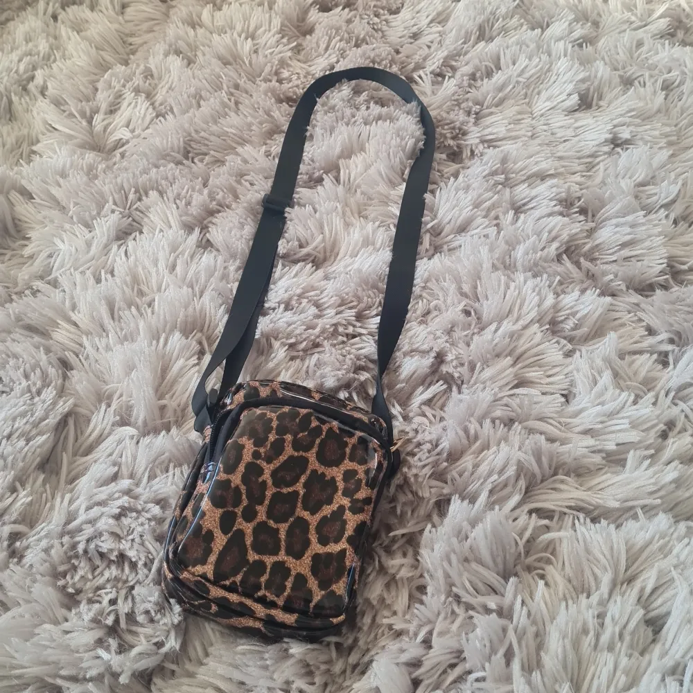 Snygg väska från Lindex, leopard mönster med glitter. Använd fåtal gånger. Rymmer plånbok, telefon och mer... Laukut & Käsilaukut.