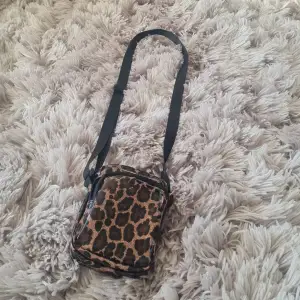 Snygg väska från Lindex, leopard mönster med glitter. Använd fåtal gånger. Rymmer plånbok, telefon och mer..