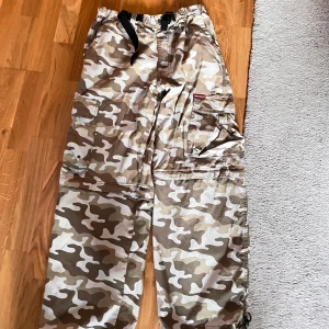 Eckö camo byxor - Ecko camo byxor baggy står L men är unge för 40 cm midja unge för 30 cm benöppning den har blixtlås och kan bli shorts men är ganska dåligt blixtlås