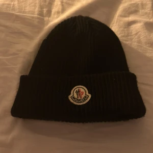 Moncler Mössa  - Har använt mössan 1 gång och det var när jag testa den då jag insåg att den vad alldeles för liten för mig. 10/10 skick. 