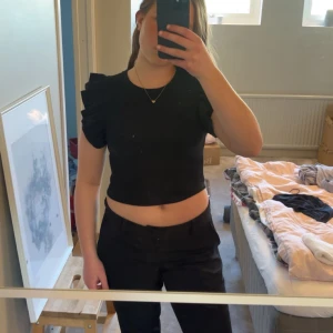 svart topp zara - En svart topp med små volanger på ärmarna, från zara. Använd ett fåtal gånger och därför i mycket bra skick. Jättefin nu till sommaren!
