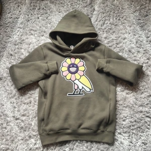 OVO / October’s Very Own x Takashi Murakami Surplus Flower Owl Olive Green Hoodie Storlek M - Detta är min favorithoodie, hidden double lined pockets, double lined luva, embroidered chenille patch där framme, 10/10. Säljer den bara för ett högt pris, jag köpte retail men tror resell är mycket dyrare. Bhvr pengar snabbt ba. Skickar samma dag ✅