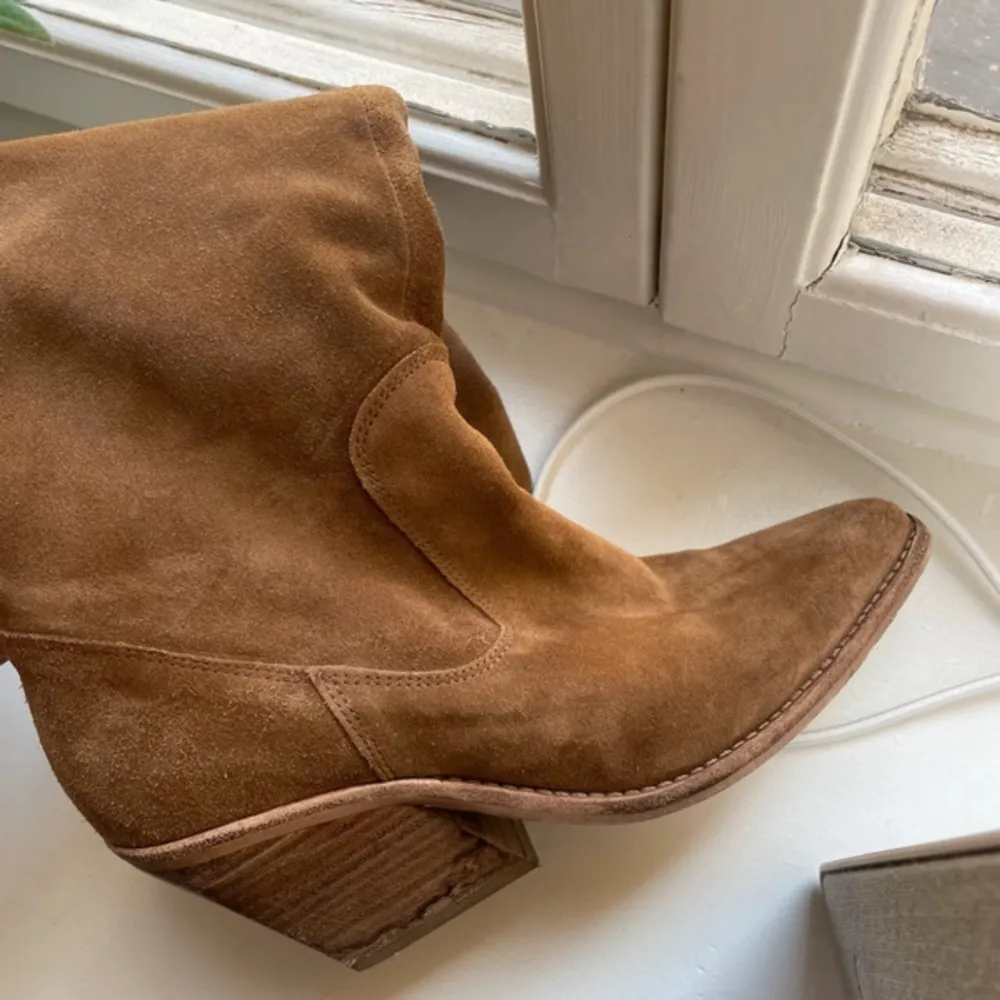 Fina cowboyboots från BRONX. Använt ett par gånger, fint skick. Storlek 37. Ljusbrun mocka. 7cm klack, 50cm hög (från hälen till skaftet). Otroligt snygga! . Skor.