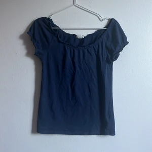 söt sommartopp - Jättegullig mörkblå topp nu till sommaren, lite singoalla/off shoulder urringning med fina detaljer. Är i storlek 158/164 men passar en xs/s. 
