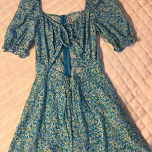 Blommig kläning  - Storlek xxs.Ät i bra skick.Det är en blå,vitt,gul kläning som har massa blommor.Det här är en klänning fast med shorts. 