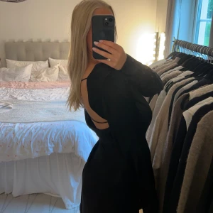 Svart klänning med öppen rugg - Svart klänning med öppen rygg och detaljer 