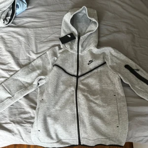 Nike tech  - Grå Nike tech den är helt ny med prislappar kvar, både koftan och byxan är i storlek M. Säljer den pågrund av den inte passar min bror. 