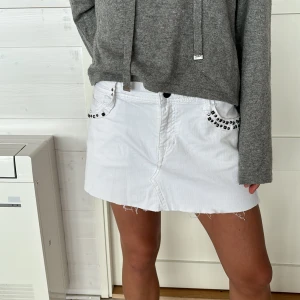 Vit miniskirt - Säljer denna vita lågmidjade jeanskjol med coola nitar, storlek 40💕OBS, på bilderna håller jag in kjolen så att den passar💕