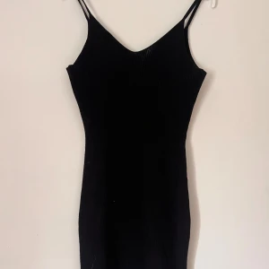 Klänning  - Snygg svart stickad klänning som är lite kortare