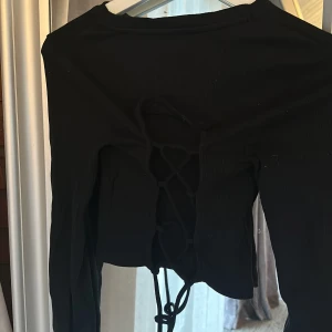 Långärmad topp m. Öppen rygg - Så snygg svart topp med knytning i tyggen, perfekt för fest! Används tyvärr aldrig🫶🏼