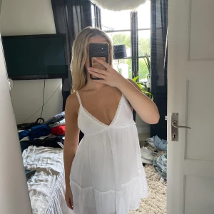 Miniklänning  - Vit kort klänning med virkade axelband och v ringning  Från Pull & Bear Storlek xs