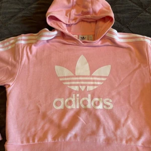 Adidas hoodie str 164 - Adidas hoodie str 164 i härlig bubbelgums rosa. Knappt använd så i nyskick. Den är kort i modellen. Lycka till