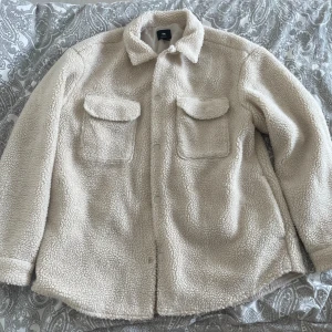 Off white H&M  Teddy jacka herr - Använd fåtal gånger. Så gott som ny, använd varsamt, ej tvättad.  Säljer då den inte kommer till användning.  Normal passform