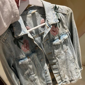 Jeansjacka med brodyr  - Ljusblå jeansjacka med brodyrer. Nyskick och väldigt sällan använd, storlek 36