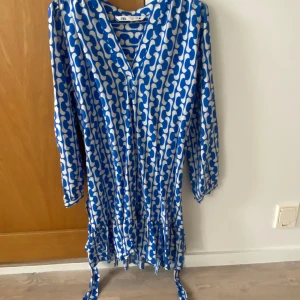 Jättefin kort sommarklänning med snörning i midjan!  - Jättefin kort v-ringad sommarklänning med snörning i midjan, stl S, endast använd en gång! Härligt luftigt material (85% viskos)! 