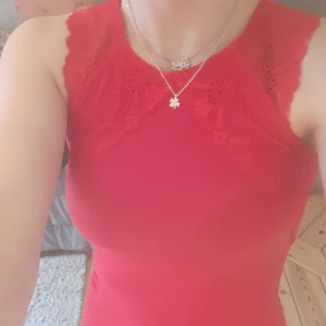 Rött spetslinne - Säljer ett så fint linne som är perfekt till julafton eller till vardagen om man känner sig festlig💞  Så fin spets som nästan "glänser" lite, spetsen fortsätter lite på ryggen. Köpt begagnad men har nästan aldrig andvänt den och är som ny💕❤