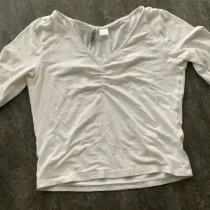 En vit långärmad tröja med scrunch i mitten av bröstet. Säljer för att jag inte använder den. Fint skick. 