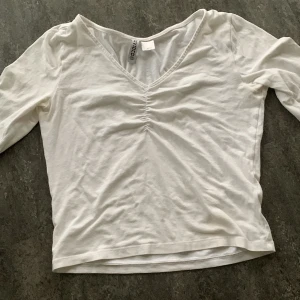 Vit långärmad tröja - En vit långärmad tröja med scrunch i mitten av bröstet. Säljer för att jag inte använder den. Fint skick. 