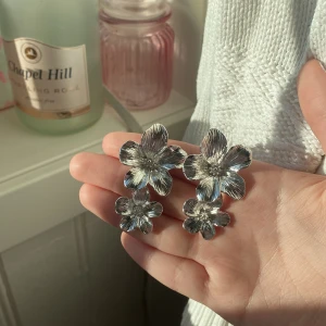Örhängen  - Säljer dessa silvriga Blom örhängena Vet ej om det är rostfritt stål!💕 Helt oanvända!!