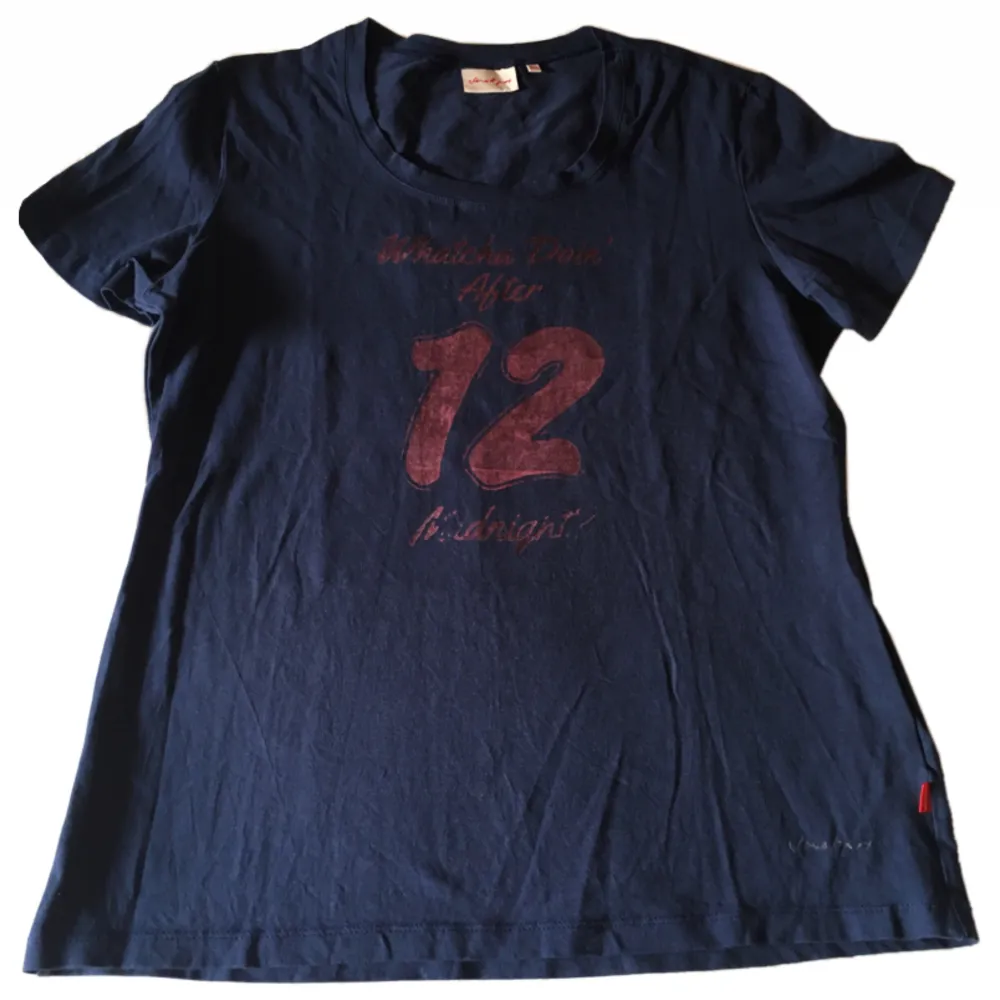 Mörkblå T-shirt med handtryckt tryck där det står ”whatcha doin’ after 12 midnight?”. T-shirts.