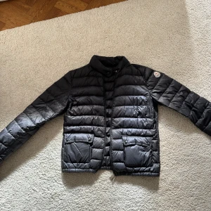 Moncler Jacka - Svart moncler jacka i tunt dun. Storlek 2. Köpt för ca 6700 kr. Nypris idag ca 10 000 kr. Inga defekter. Kvitto finns. 
