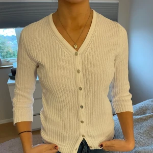 Ribbad topp - Jättefin topp från mexx som funkar jättebra nu till våren. Ribbat material och trekvartsärmar, fina knappar framtill. Mycket bra skick.  