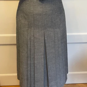 Elegant kjol - Välsittande högt skuren fodrad 70-talskjol, använd men nära nyskick. 75,5 cm i midjan, längd 72 cm. Vattentvätt 40 grader.