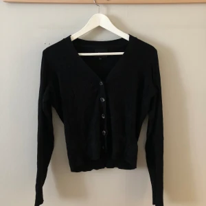 Svart tröja från Object med knappar - Svart tröja i stickat mjukt material som knäppa framtill med knappar!  Använt skick