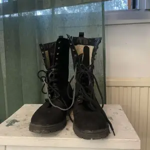 Knähöga boots med snöring och blixtlås på sidan. Behöver nya skosnören då dom som är på nog sett sin sista snöring