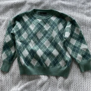 Grön stickad rutig tröja - Grön rutig tröja. Något korta armar. Fint tyg, från shien
