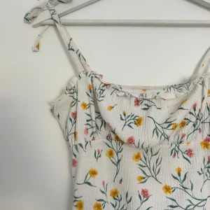 Minidress - Kort blommig klänning från hm med gulliga detaljer vid bysten och på axelbanden💕🌸