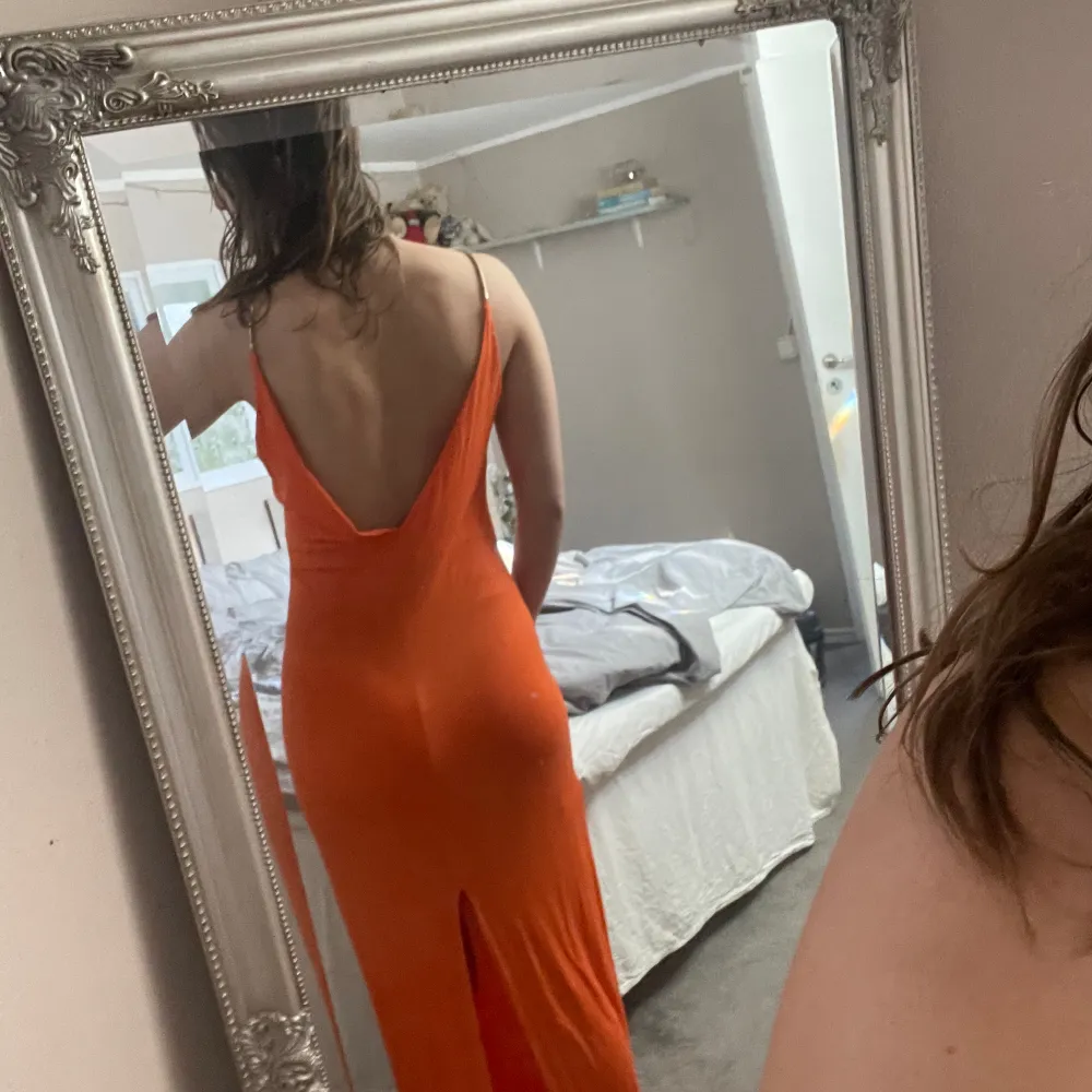 Orange långklänning från HM. Väldigt skönt material, och fina metalldetaljer på axelbanden. Djup i ryggen. Använd men i bra skick . Mekot.