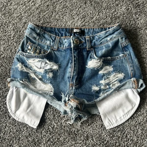 Jeansshorts - Slitna short, med nitar. Knappt använda.  Strl XS