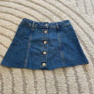 En kort low waist jeans kjol med knappar. Super fin och sällan använd.