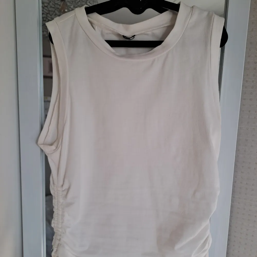 Ett vitt linne som har blivit för liten. 🩷Linnet är i nyskick och har bara använts en gång✨️ Den randiga tröjan i bakrunden säljet jag också, i ett annat inlägg.🩷🩷. Toppar.